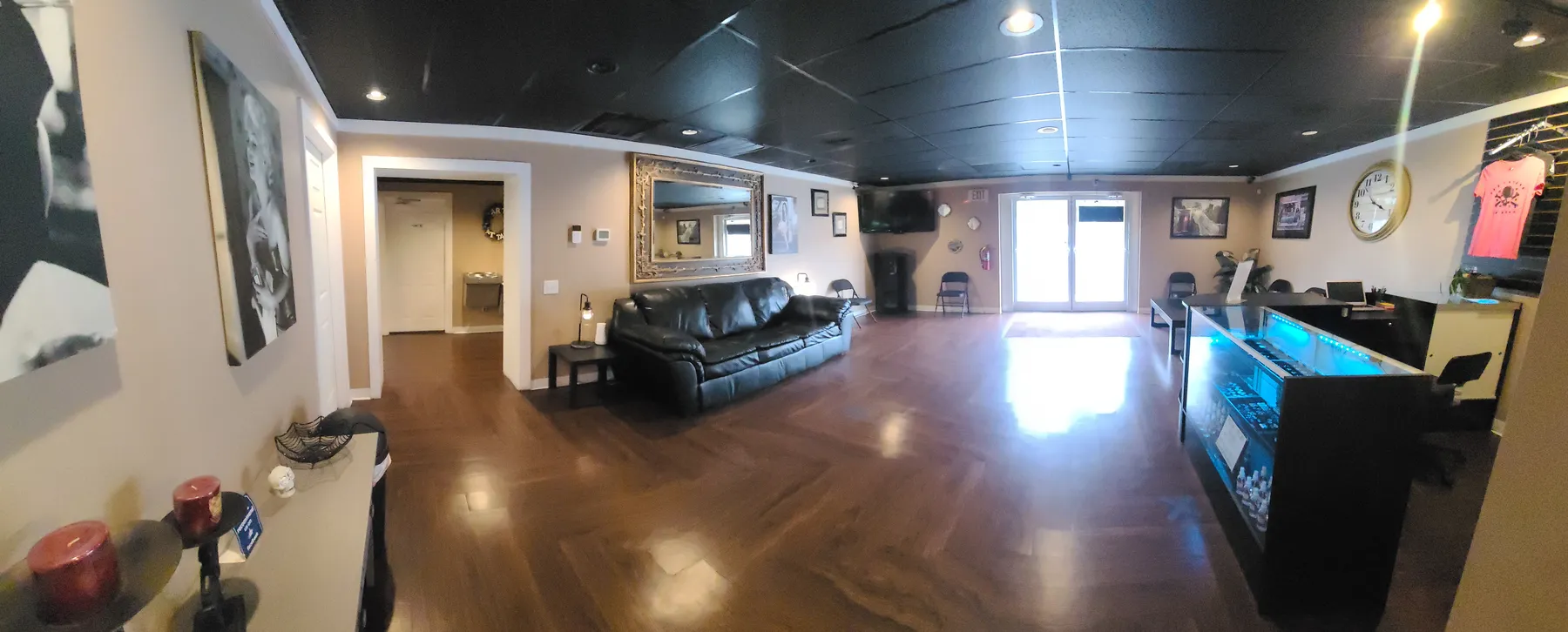 Inside the Art Attack Tattoo studio: clean lobby with seating, front counter and wood floors